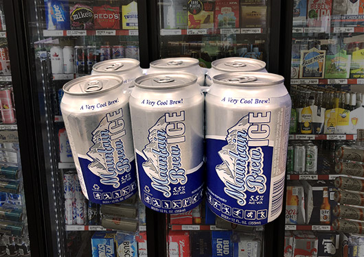 Six pack of Mountain Brew Ice in front of a cooler