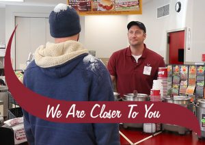 We are closer to you. two people in the photo. One customer with snow on his sweatshirt and one Stewarts employee.